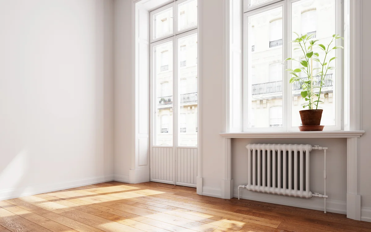 Empty room with tall windows and clean wood floors