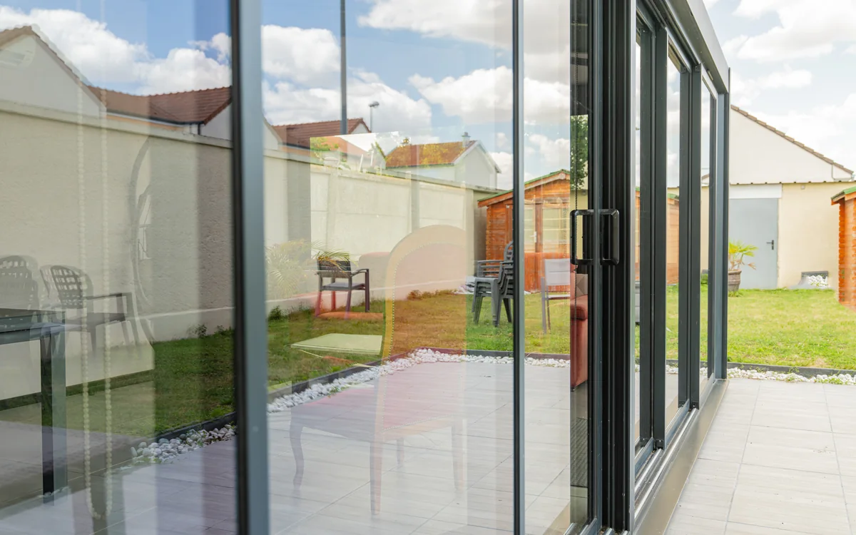 Large glass doors opening onto a clean backyard
